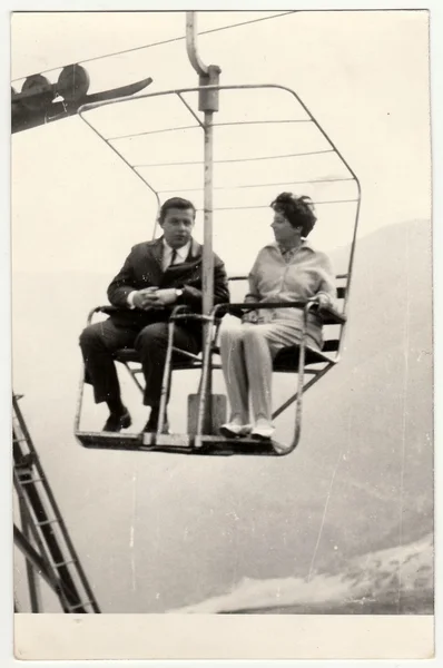 Retro photo of a marrital couple on a chair lift, 1970s.