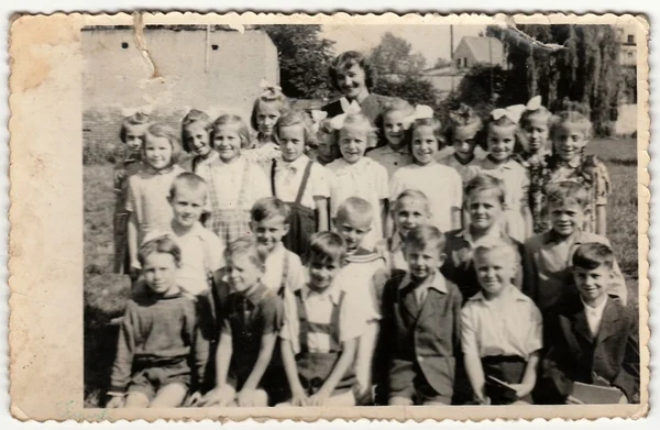 Vintage photo shows pupils (schoolmates)  and their female teacher.