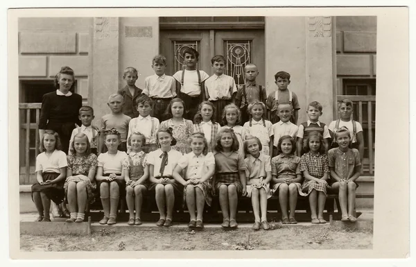 Vintage photo shows pupils (schoolmates)  and their female teacher.