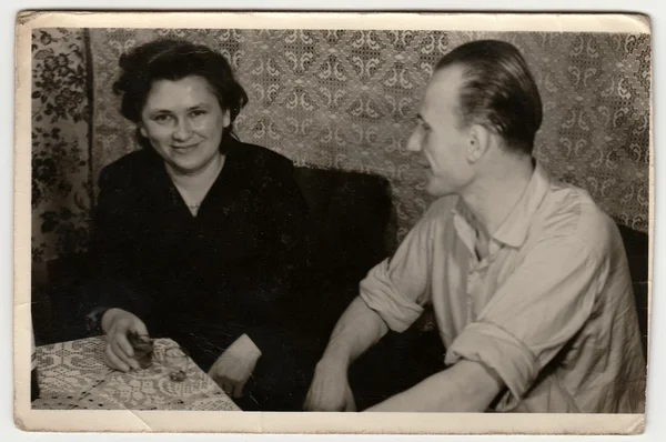 Vintage photo shows woman and man drink spirits (liquors).