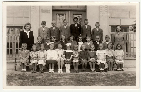 Vintage photo shows pupils (schoolmates)  and their female teacher.