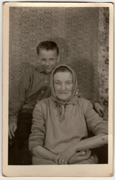 Vintage photo shows grandson with grandmother.