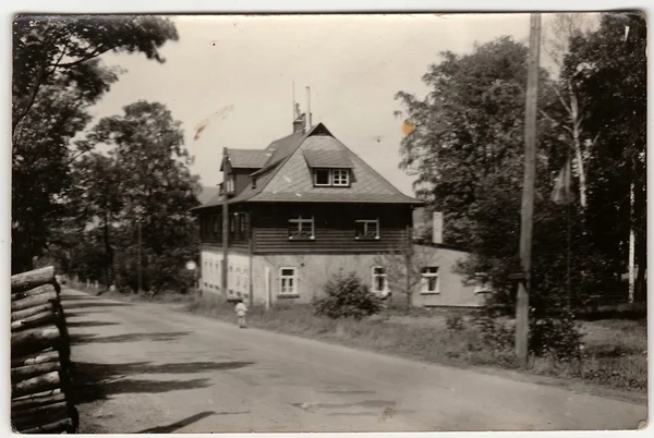 A vintage photo shows mountain cottage. An antique Black & White photo.