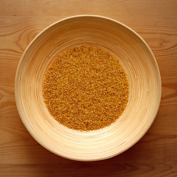 Bamboo Bowl with Bulgur on Wood Background