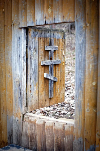 The cross on a wooden door. Entrance to the monastery