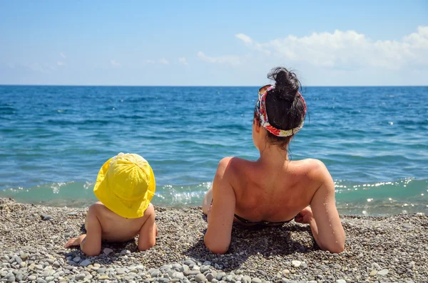 Mother and daughter sunbathe on the beach