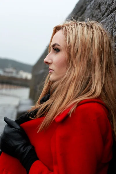 Profile of a young woman wearing a red coat