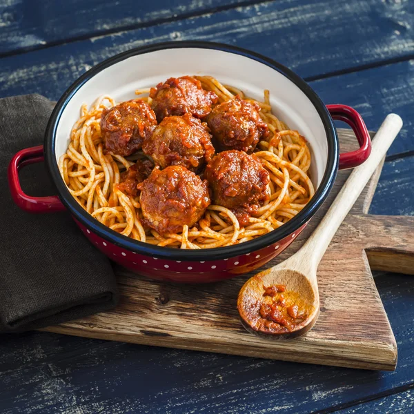 Spaghetti and meatballs in tomato sauce on wooden rustic board. Delicious lunch