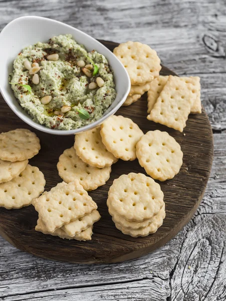 Cheese biscuits and avocado hummus on rustic wooden background