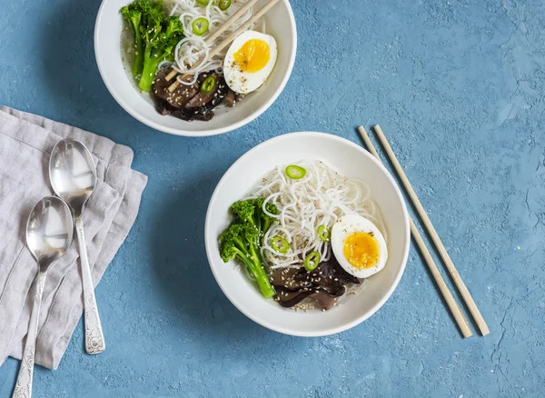 Rice noodles soup with broccoli, mushrooms and boiled egg. Healthy vegetarian food, top view