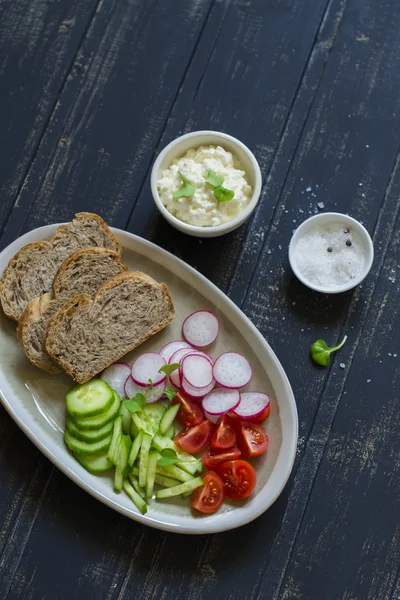 Ingredients for whole wheat toasts with cheese, radish, cucumber, cherry tomatoes