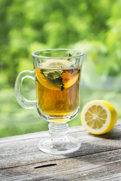 Green tea with mint and lemon in a glass mug