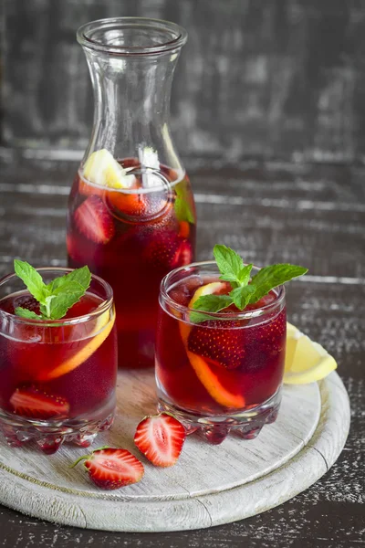 Strawberry lemonade with fresh mint and lemon in glass beakers