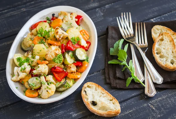 Roasted vegetables - zucchini, cauliflower, potatoes, carrots, onions, peppers, on an oval dish