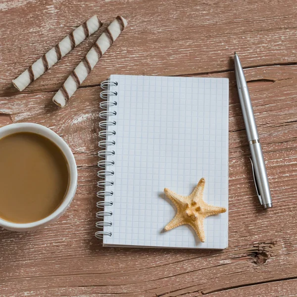 Clean blank notepad, cookies, cup of coffee,  starfish. Travel and weekends background. Free space for text. Top view