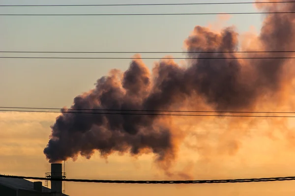 A chimney of a factory with smoke