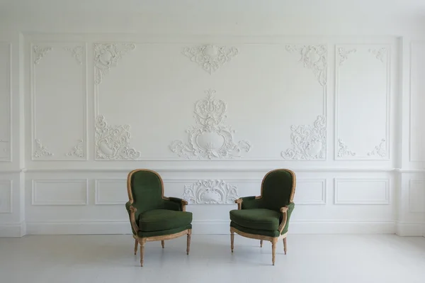 Luxury clean bright white interior with a old antique vintage green chairs over wall design bas-relief stucco mouldings roccoco elements