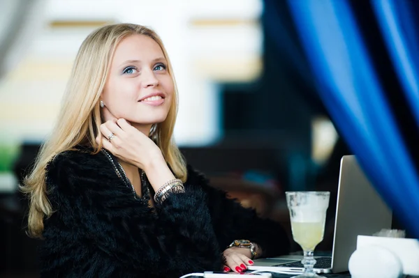 Young gorgeous European woman with pretty face thinking about something while sitting with laptop computer in cafe bar, dreamy beautiful female using portable net-book during work break in coffee shop