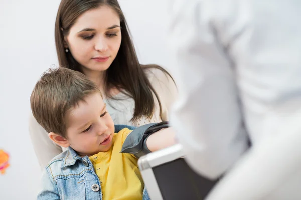 Little boy medical visit - doctor measuring blood pressure of a child