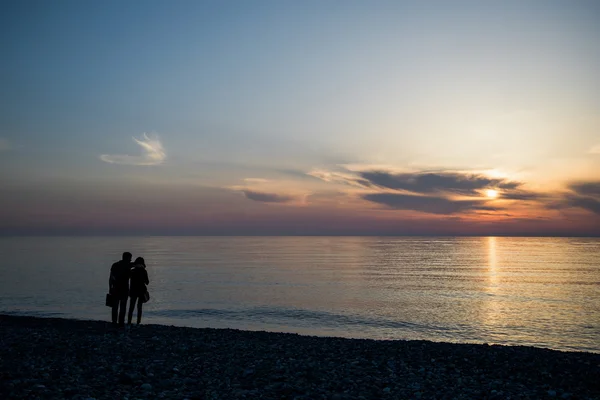 Couple in love back light silhouette at lake sunset full length