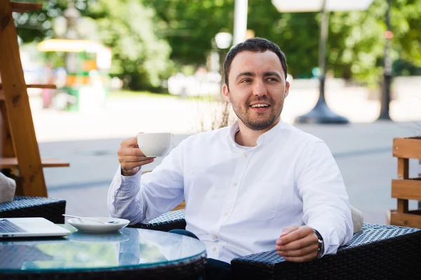 Confident successful businessman in suit enjoying a cup of coffee while having work break lunch in modern restaurant,young intelligent man or entrepreneur relaxing in outdoors cafe looking pensive