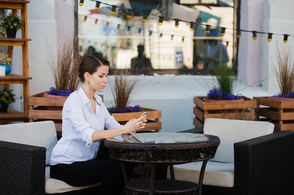 Lovely business woman with smile is sitting with touch pad in comfortable restaurant during recreation time, happy female student relaxes in coffee shop after university