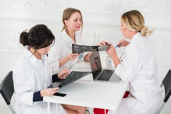 Group Of Doctors Having Meeting In A Hospital office examining x-ray