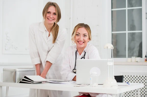 Two Female friendly cheerful Doctors or Nurses Isolated in office smiling and looking at camera