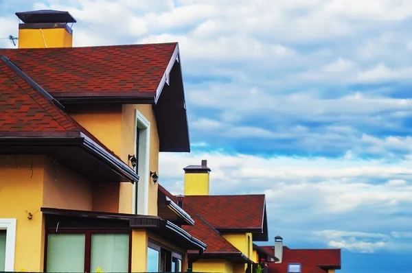 Roofs of houses, cloudy sky