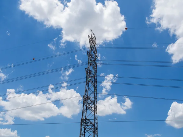 The side of High voltage pole on clouds and sky background.