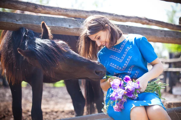 Girl is feeding a horse