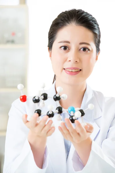 Asian female scientist looking at molecular model doing the scie