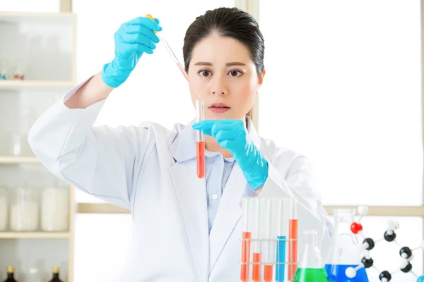 Asian female forensic scientist working on chemicals