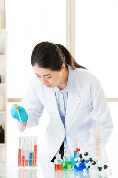 Young asian scientist pipetting in life science laboratory