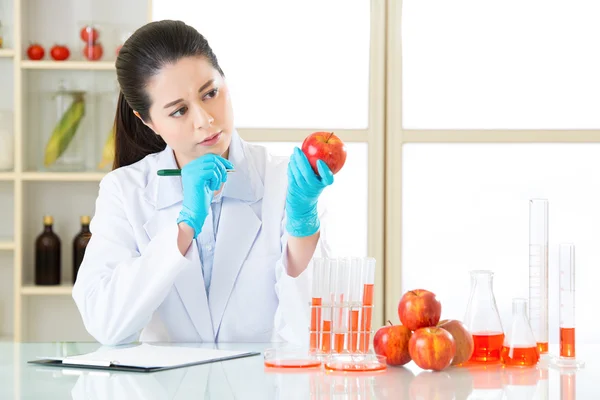 Asian female scientist thinking and holding an apple