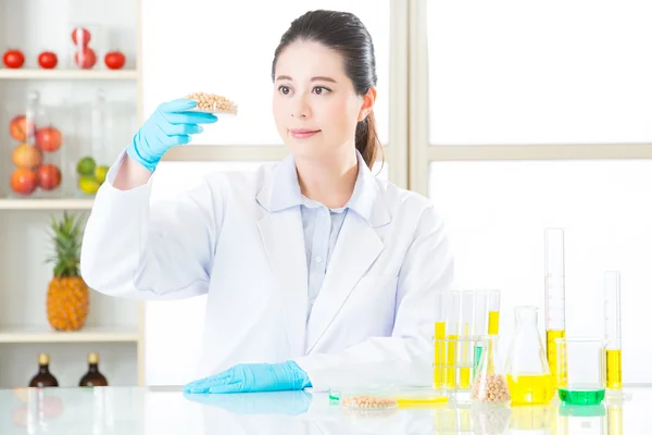 Asian female scientist looking soya bean for genetic modificatio