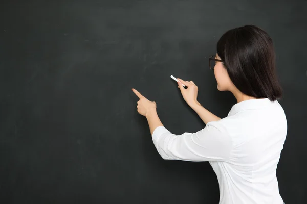 A good asian teacher writing question on blackboard with chalk
