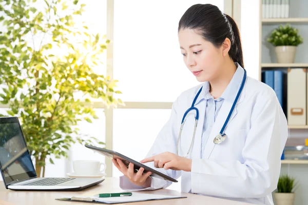 Doctor using digital tablet to research patient's medical case