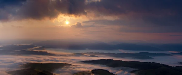 Misty sunrise in Carpathian Mountains panorama