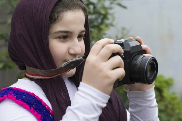 Little Girl Is Taking Photograph by An old Analogue Camera Strap