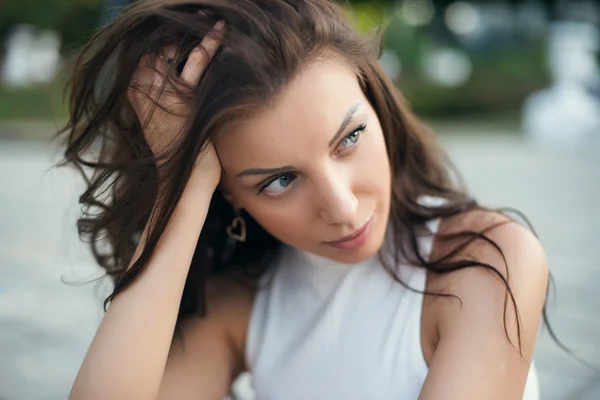 Sexy sensual woman posing with big eyes and full lips at evening sunlight in city park