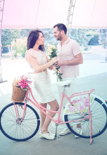 Couple with pink vintage bicycle in the summer park