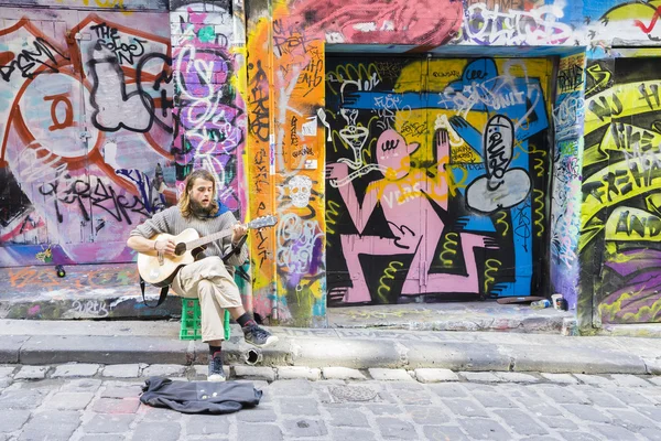 Street musician playing guitar in laneway