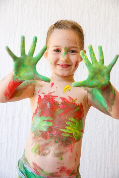 Little girl showing her hands, covered in finger paint