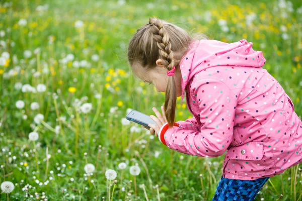 Little girl photographing with her smartphone