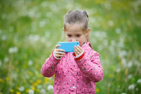 Little girl photographing with her smart phone