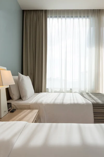 Bed room with white pillows , sheets and curtain