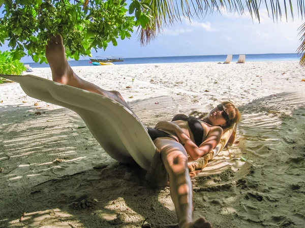 Woman spleeping under coconut palm