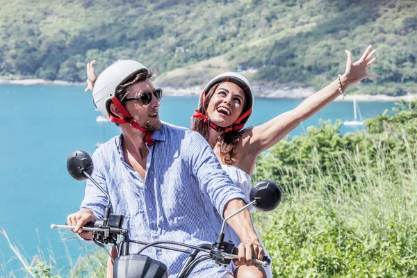 Cheerful couple riding scooter