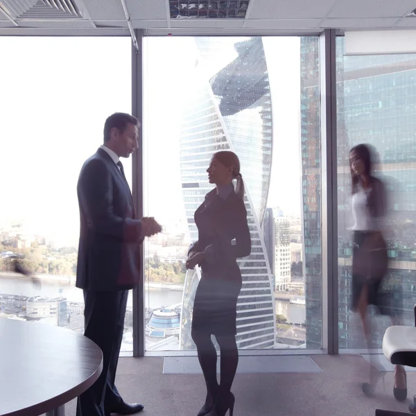 Business people talking in a conference room with city skyline